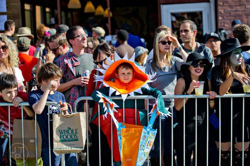 Dressed as a venus fly trap, Jonah McKenzie (center) holds his bag of candy open during the 14th annual Little 5 Points Halloween Parade in Atlanta on Saturday, October 18, 2014. 
