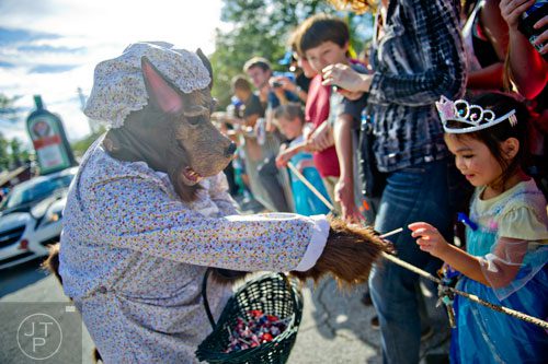 Dressed as The Big Bad Wolf, Sam Smith (left) hands a piece of candy to Maia Lemmon as he marches in the 14th annual Little 5 Points Halloween Parade in Atlanta on Saturday, October 18, 2014.
