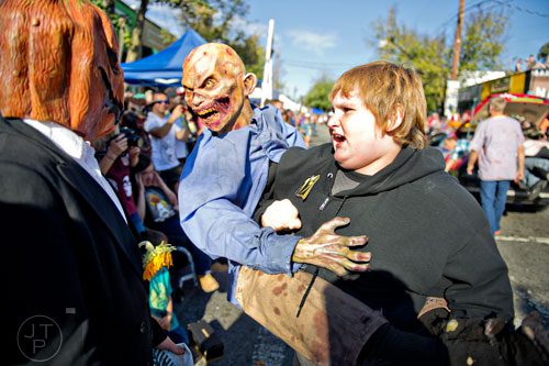Brayden Bartholf (right) uses a zombie to scare people as he marches in the 14th annual Little 5 Points Halloween Parade in Atlanta on Saturday, October 18, 2014. 