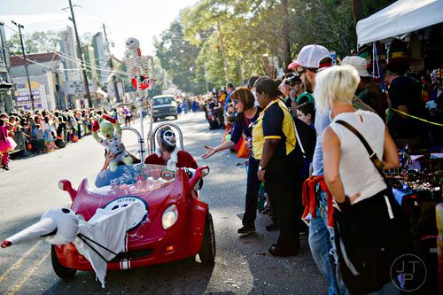 Chad Mercer (center) drives a vehicle up Euclid Ave. during the 14th annual Little 5 Points Halloween Parade in Atlanta on Saturday, October 18, 2014. 