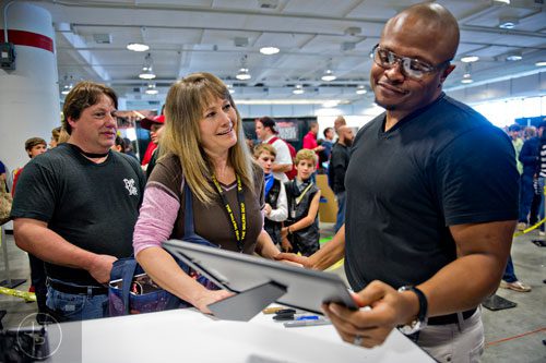 IronE Singleton (right), who portrayed T-Dog on the Walking Dead, is given a photograph by Norma Jean Crebs and Cleave Whitley during Walker Stalker Con in Atlanta on Sunday, October 19, 2014. 
