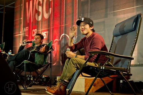Steven Yeun (right), who portrays Glenn on the Walking Dead, waves to fans at a panel during Walker Stalker Con in Atlanta on Sunday, October 19, 2014. 