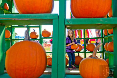 Savannah McHughes selects the perfect pumpkin at Corn Dawgs in Loganville on Sunday, October 5, 2014.  