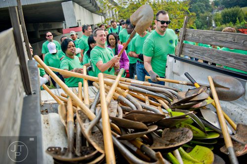 April Wilkerson (left), Mike Stone and David Bates grab shovels out of the back of a truck as they help plant 80 trees along the Atlanta Beltline on Wednesday, October 8, 2014. 