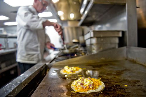 Egg and ham quesadillas cook on the grill as Chef Russell Sleight prepares a pastel spinach omelette at The Cafe inside the Westin Peachtree Plaza hotel in Atlanta on Wednesday, October 8, 2014. 