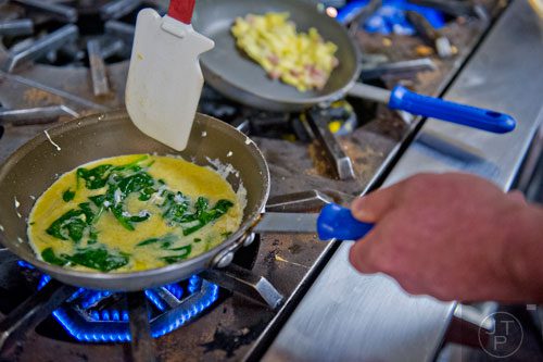 Chef Russell Sleight prepares a pastel spinach omelette at The Cafe inside the Westin Peachtree Plaza hotel in Atlanta on Wednesday, October 8, 2014. 