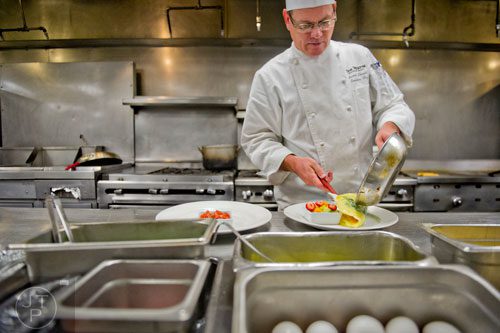 Chef Russell Sleight plates a pastel spinach omelette at The Cafe inside the Westin Peachtree Plaza hotel in Atlanta on Wednesday, October 8, 2014. 