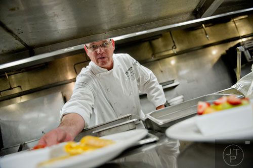 Chef Russell Sleight hands off a plate of egg and ham quesadillas at The Cafe inside the Westin Peachtree Plaza hotel in Atlanta on Wednesday, October 8, 2014. 