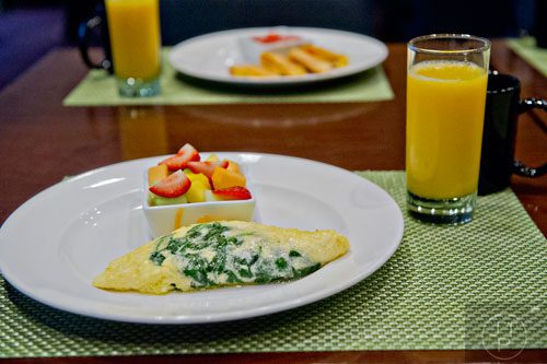 A pastel spinach omelette with a side of fresh fruit and egg and ham quesadillas with pico de gallo sit on plates at The Cafe inside the Westin Peachtree Plaza hotel in Atlanta on Wednesday, October 8, 2014. 