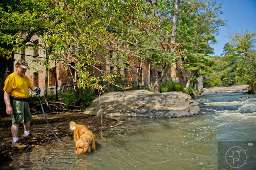 Charles Scott hikes near the water and the ruins of the New Manchester Mill with his golden retriever Rosebud at Sweetwater Creek State Park in Lithia Springs on Monday, September 22, 2014. 