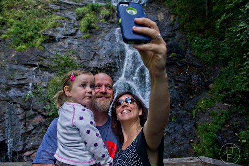 Sydney Dillard (left) takes a selfie with her parents Jason and Janet in front of Amicalola Falls at Amicalola State Park in Dawsonville on Tuesday, September 23, 2014. 