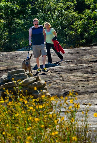 Seth Johnstone (left) and his wife Kellei follow the cairns that mark the path as they hike down Arabia Mountain in Lithonia with their dog Izzei on Wednesday, September 24, 2014.   