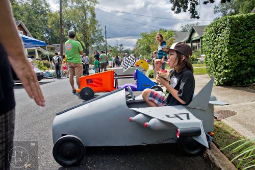Jack Kelly takes a bite of ice cream as he sits in his car made to look like a fighter jet from the movie Top Gun before the start of the 4th annual Madison Ave. Soap Box Derby in Decatur on Saturday, September 27, 2014.