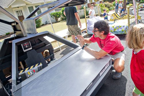 Brady Lewis takes a photo of the delorean from the movie Back to the Future before the start of the 4th annual Madison Ave. Soap Box Derby in Decatur on Saturday, September 27, 2014.