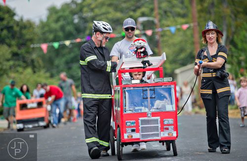 Eric Blue (left) and his wife Erin escort their son Dylan to the starting line during the 4th annual Madison Ave. Soap Box Derby in Decatur on Saturday, September 27, 2014.