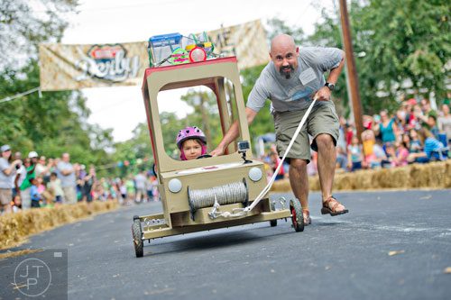 Josh Netherton (right) helps his four year old daughter Penelope steer her car down Madison Ave. in Decatur during the 4th annual Madison Ave. Soap Box Derby on Saturday, September 27, 2014.