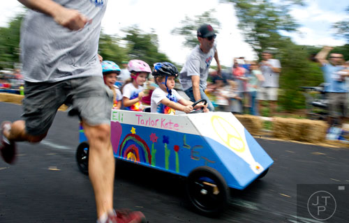 Taylor Kate Garner and Lucy Scalese ride shotgun as Elijah Dailey steers down Madison Ave. in Decatur during the 4th annual Madison Ave. Soap Box Derby on Saturday, September 27, 2014.