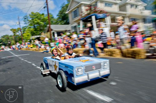 Lola DiCarlo (left) rides shotgun next to her brother Rocco as he steers down Madison Ave. in Decatur during the 4th annual Madison Ave. Soap Box Derby on Saturday, September 27, 2014.