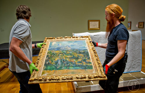 Ed Hill (left) and Tommy Sapp move Paul Cezanne's oil on canvas Mont Sainte-Victoire to a table before it is hung in the High Museum of Art's new "Cezanne and the Modern: Masterpieces of European Art from the Pearlman Collection" exhibit on Tuesday, October 14, 2014. 