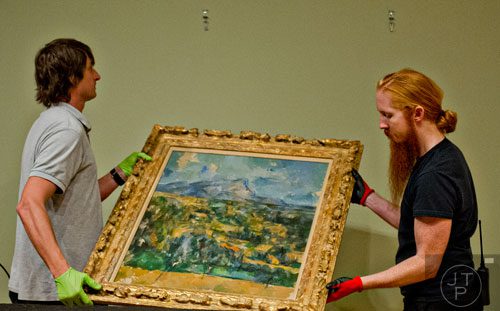 Ed Hill (left) and Tommy Sapp hang Paul Cezanne's oil on canvas Mont Sainte-Victoire in the High Museum of Art's new "Cezanne and the Modern: Masterpieces of European Art from the Pearlman Collection" exhibit on Tuesday, October 14, 2014. 