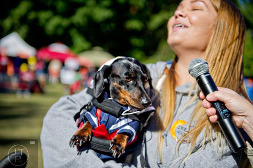 Skye Kaleta tries to coax her dachshund Artie to howl during Howl-O-Weenie at Liane Levetan Park at Brook Run in Dunwoody on Saturday, October 4, 2014. 