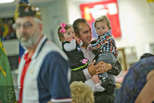 Will Guzman (center) holds his twins Emma Ruth (left) and William III as they wait for the arrival of  Republican candidate David Perdue and senators John McCain and Johnny Isakson who spoke to a crowd of supporters at the VFW Post 2681 in Marietta on Wednesday, October 15, 2014.  