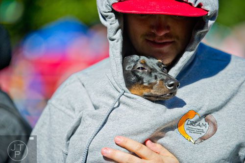 Brutus is held inside a hoodie by his owner Mike McEarchern before the kissing contest begins during Howl-O-Weenie at Liane Levetan Park at Brook Run in Dunwoody on Saturday, October 4, 2014. 