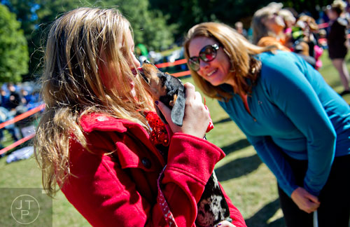 Maren Hite (left) is licked by her dachshund Sydney as Amy Yarkoni counts in the kissing contest during Howl-O-Weenie at Liane Levetan Park at Brook Run in Dunwoody on Saturday, October 4, 2014. 