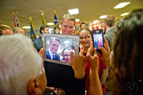 Republican candidate David Perdue (left) has his photo taken with Isabella Peck after speaking at the VFW Post 2681 in Marietta on Wednesday, October 15, 2014.  