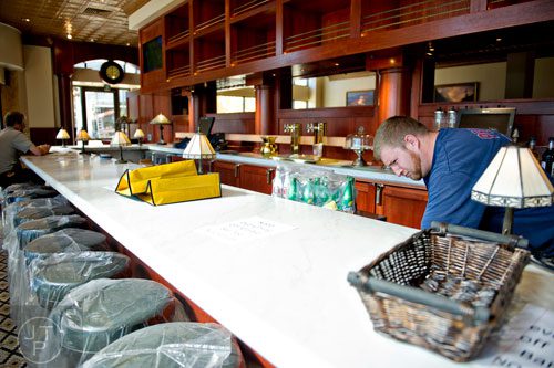 Jon Cameron (right) grabs supplies behind the bar inside Ted's Montana Grill at the new Avalon development in Alpharetta on Friday, October 17, 2014. 
