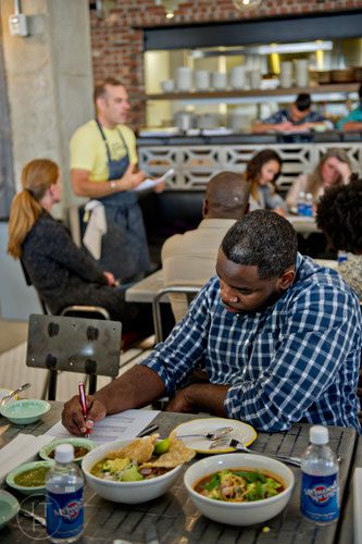 Julian Wright (right) takes notes as Chef Kevin Maxey explains the menu to new employees at The El Felix inside the new Avalon development in Alpharetta on Friday, October 17, 2014. 