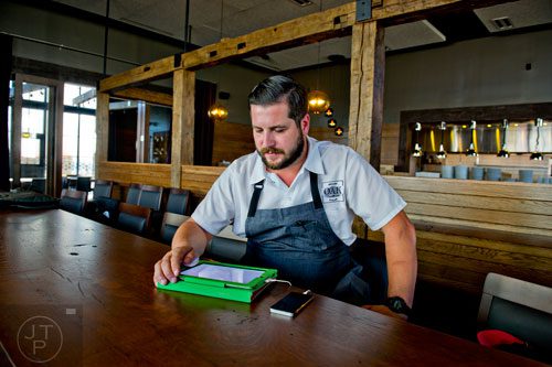 Chef Chad Anderson finishes ordering supplies as he sits at the bar at Oak Steakhouse at the new Avalon development in Alpharetta on Friday, October 17, 2014. 