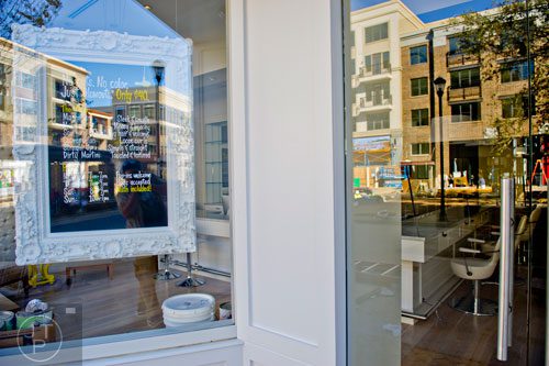 A view of the shopping district inside the Avalon development in Alpharetta is reflected in the store front windows of drybar on Friday, October 17, 2014.