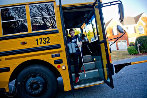 Christopher Abel (center) steps off of the school bus down the street from his home in Acworth on Friday, November 14, 2014. 