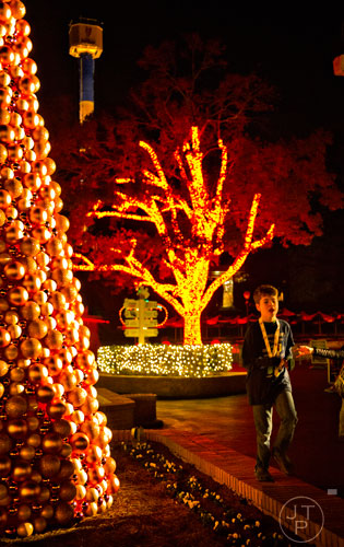 Tyler Harte walks past an orange Christmas tree inside Six Flags Over Georgia in Austell on Friday, November 21, 2014. 