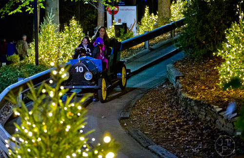 Lindsey Feyerabend (left), her mother Paula and Ava Perez ride the Hanson Cars inside Six Flags Over Georgia in Austell on Friday, November 21, 2014. 