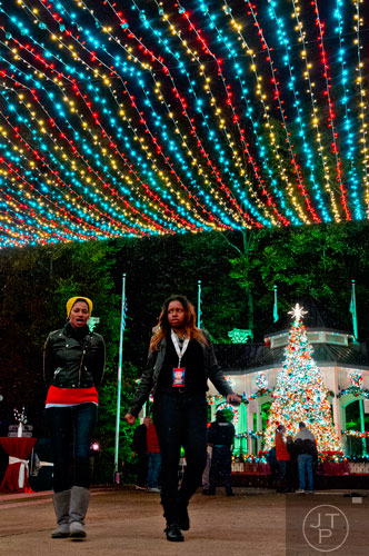 Julia Eze (left) and Ashley Smith walk underneath holiday lights inside Six Flags Over Georgia in Austell on Friday, November 21, 2014. 