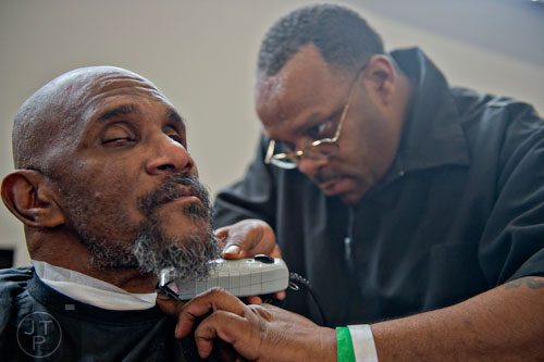 Earl Thompson (left) gets his beard trimmed by Christopher Clark during the 44th annual Hosea Feed the Hungry and Homeless Thanksgiving Holiday Dinner at the Georgia World Congress Center in Atlanta on Thursday, November 27, 2014. 