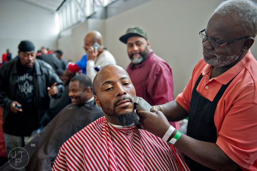 Shauntell Johnson (left) gets his beard trimmed by Slack Williams during the 44th annual Hosea Feed the Hungry and Homeless Thanksgiving Holiday Dinner at the Georgia World Congress Center in Atlanta on Thursday, November 27, 2014. 