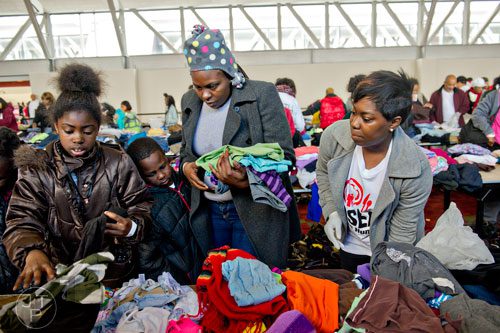 Asia Lockett (left), her brother Jakaira and mother Tacarra pick out clothes with the help of Krystle White during the 44th annual Hosea Feed the Hungry and Homeless Thanksgiving Holiday Dinner at the Georgia World Congress Center in Atlanta on Thursday, November 27, 2014.