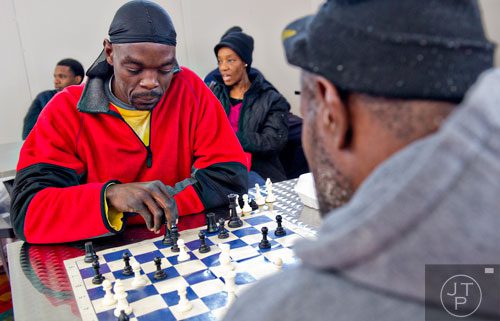Earl Bozack (left) plays a game of chess as he keeps warm inside during the 44th annual Hosea Feed the Hungry and Homeless Thanksgiving Holiday Dinner at the Georgia World Congress Center in Atlanta on Thursday, November 27, 2014. 