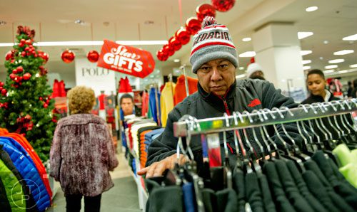Rafael Garcia (right) looks at jackets at Macy's inside Lenox Square Mall in Atlanta after doors open for Black Friday on Thursday, November 27, 2014.  