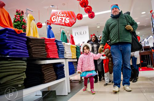 Ken Feinberg (right) holds his daughter Anauka's hand as they walk through Macy's at Lenox Square Mall in Atlanta after doors open for Black Friday on Thursday, November 27, 2014. 