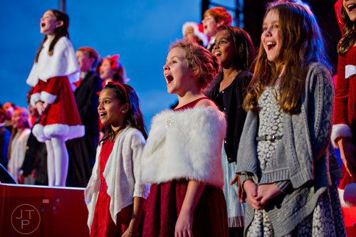 Lilia Bohntinsky (right), Niamh Harris and Shobini Palaniappan perform on stage with the Sarah Smith Elementary School Choir during the annual Macy's Great Tree Lighting celebration at Lenox Square Mall in Atlanta on Thursday, November 27, 2014. 