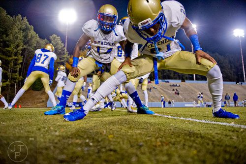 McEachern's T.J. Rahming (21) and DaMarcus Morgan (14) stretch with their teammates before their game against Tucker on Friday, November 28, 2014.   