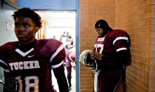 Tucker's Jarelle Leverette (right) takes a quiet moment outside the locker room as Marcus Jenkins (18) and other teammates start to file out before their game against McEachern on Friday, November 28, 2014.  