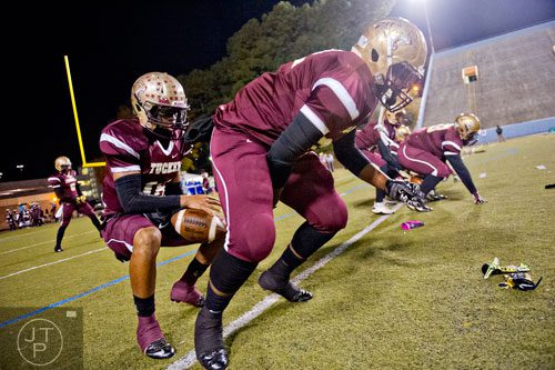 Tucker's Garrett Rigby (left) is hiked the ball by teammate Donovan Carpenter as they warm up before their game against McEachern on Friday, November 28, 2014.   