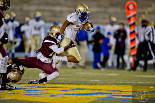 McEachern's  Sam Jackson (1) is wrapped up by Tucker's John Brooks (12) as he moves the ball towards the end zone on Friday, November 28, 2014.