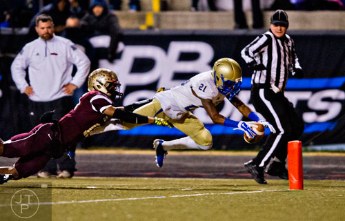 McEachern's  T.J. Rahming (21) dives for the end zone as he is tackled by Tucker's Garrett Rigby (left) on Friday, November 28, 2014.