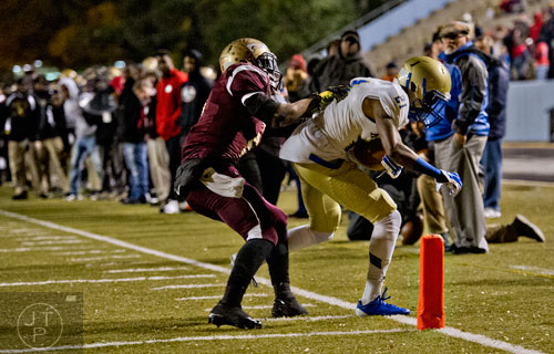 McEachern's  T.J. Rahming (21) is pushed out of bounds just shy of the end zone by Tucker's Akeam Peters (left) on Friday, November 28, 2014. 